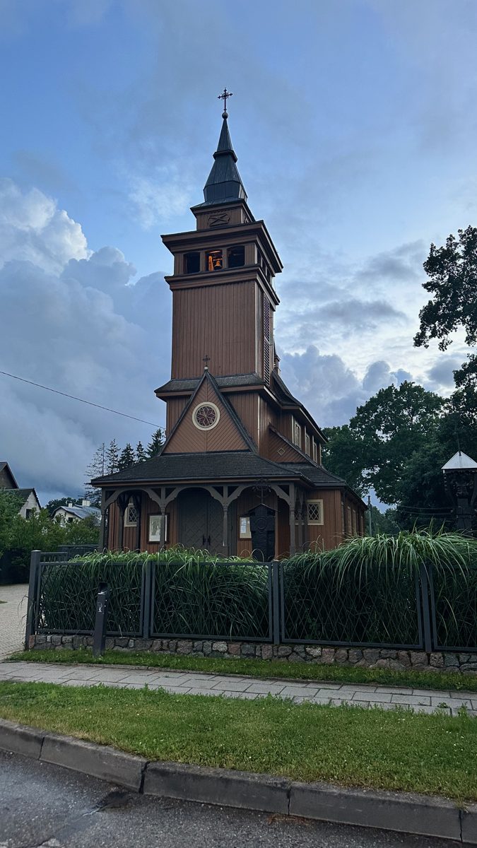 A wooden church tower against a dusk sky at the end of the walk.